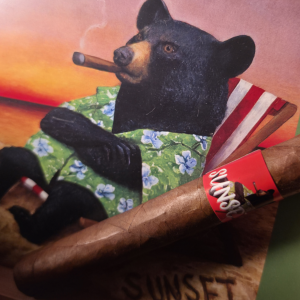 Sunset Toro cigar card featuring a bear smoking in a beach chair, with strength rated 3 of 5 and tasting notes.
